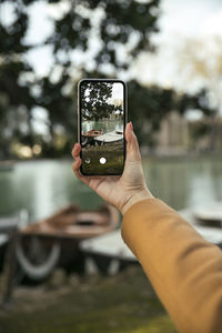 Midsection of person photographing camera on smart phone