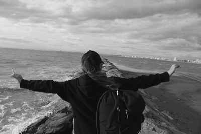 Rear view of woman looking at sea against sky