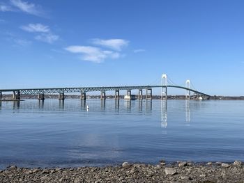 Bridge over sea against blue sky