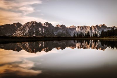 Scenic view of lake by mountains against sky