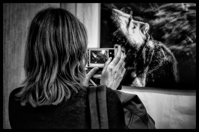 Rear view of woman photographing