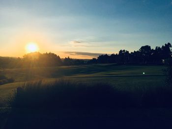 Scenic view of field against sky during sunset