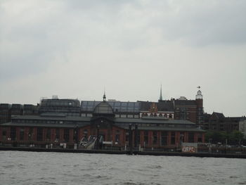 Buildings in city against cloudy sky