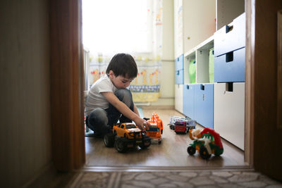 Child boy playing alone in the room, loneliness and sadness