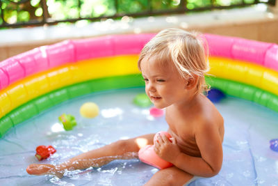 High angle view of shirtless boy swimming in pool