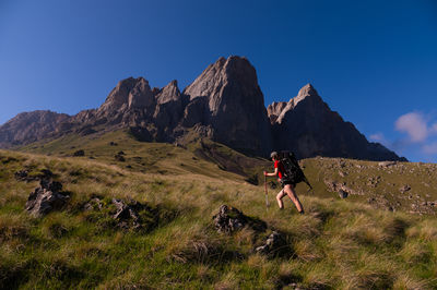 Rear view of man standing on mountain against clear sky