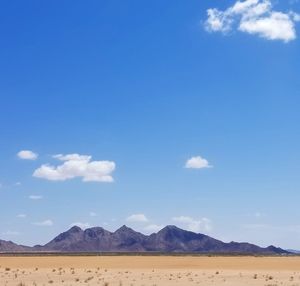 Scenic view of desert against blue sky