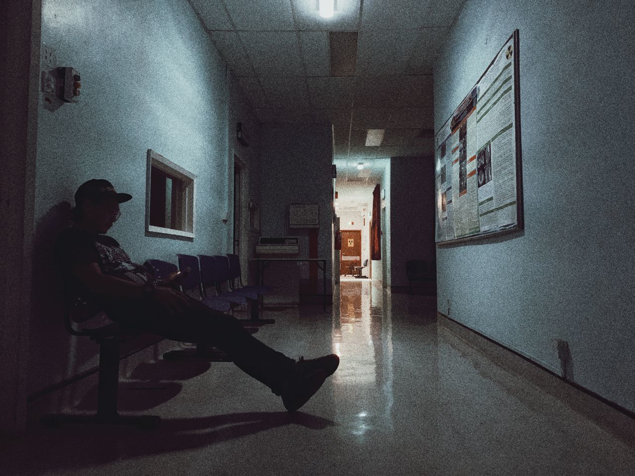 SIDE VIEW OF WOMAN SITTING ON SEAT IN BUILDING