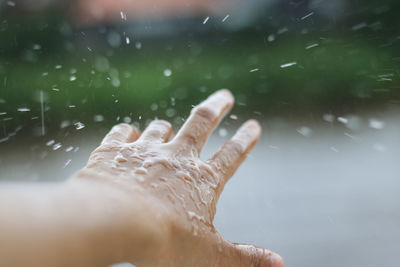 Close-up of hand splashing water in rain