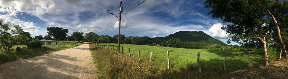 Panoramic view of agricultural field against sky