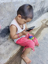 High angle view of girl holding mobile phone