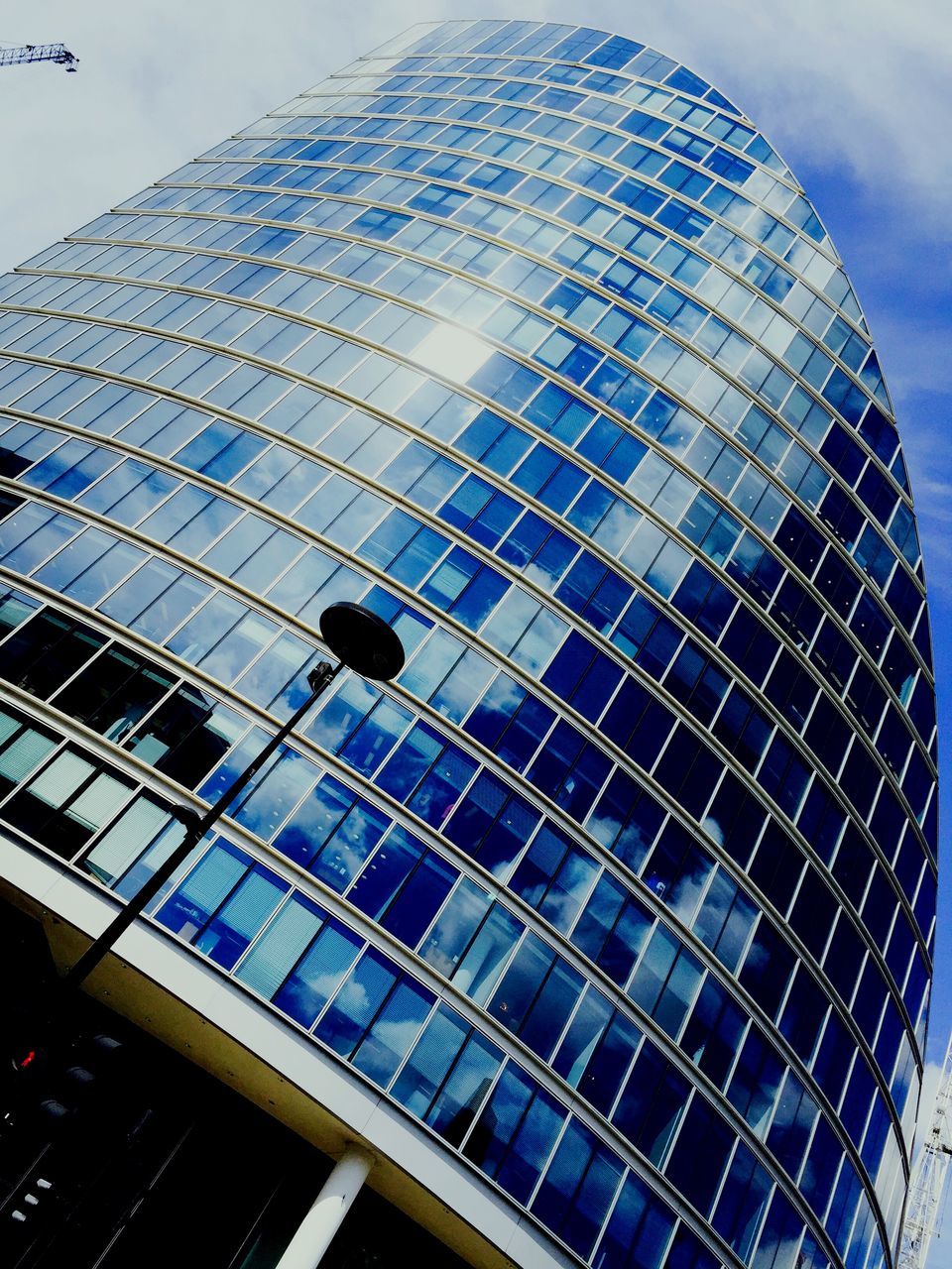 LOW ANGLE VIEW OF GLASS BUILDING WITH REFLECTION