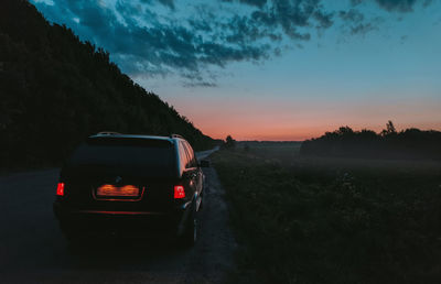 Car on road against sky during sunset