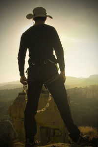 Rear view of man standing on landscape against sky