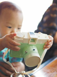 Close-up of cute baby playing with toy camera