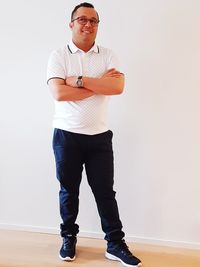 Portrait of young man standing against wall
