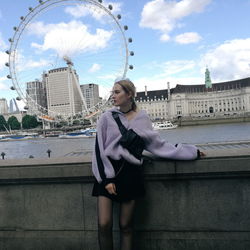 Young woman looking away while standing in city