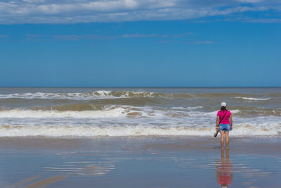 Full length of boy on beach against sky