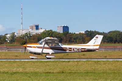 Side view of airplane on land against sky