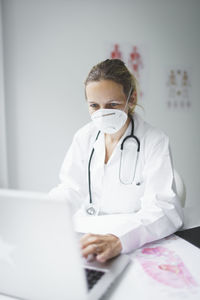Female doctor using laptop in hospital