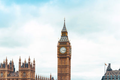 Low angle view of clock tower against cloudy sky