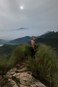 Man standing on mountain against sky
