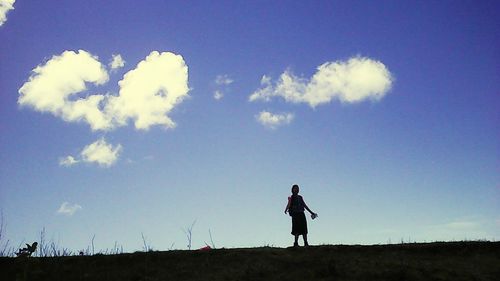 Full length of woman standing on field against sky
