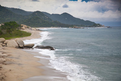 Scenic view of sea and mountains against sky