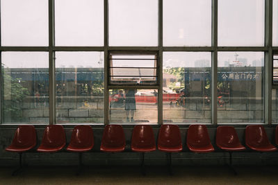 Empty chairs against window in city