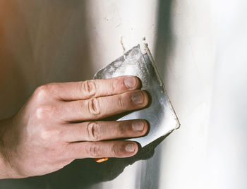 Cropped hand of worker plastering wall