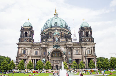 People in front of berlin cathedral against cloudy sky