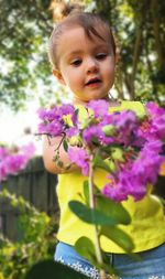 Close-up of girl with purple flowering plants