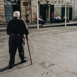 Rear view of men walking on footpath