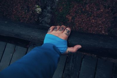 Cropped image of hand with love tattoo on fingers