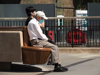 Side view of man sitting on bench