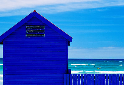 Built structure by sea against blue sky