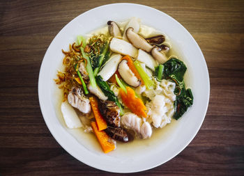 Dish of asian flat kuay tiao with spinach carrot mushrooms