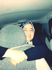 Portrait of a smiling young woman in car