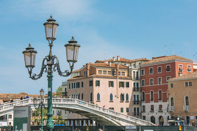 High section of lamp post against built structures