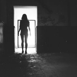 Rear view of man standing against door