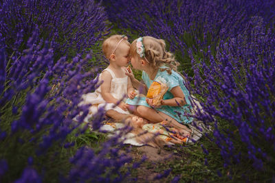 Side view of woman picking flowers on field