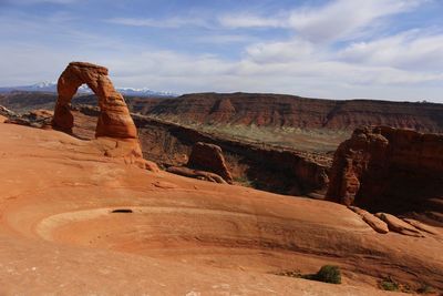 Scenic view of rock formations against cloudy sky
