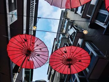 Low angle view of lanterns hanging by building against sky