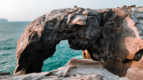 Rock formations by sea against sky