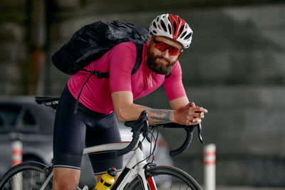 Side view of man riding bicycle on street