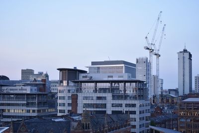 Buildings in city against clear sky