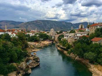 River amidst buildings in town against sky