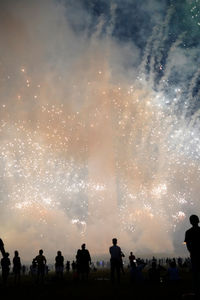 Smoke and firework explosion in fromn of washington monument, usa and silhouettes of spectators