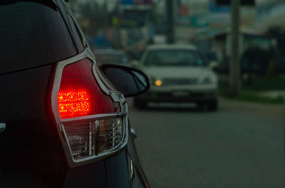 Illuminated street light on road in city