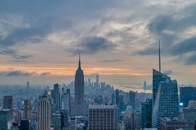 Buildings in city against cloudy sky